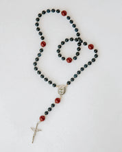 Rosary with black and red beads on a white background