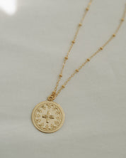 West Coast Catholic Communion necklace, 14K gold-filled Eucharist Host and cross pendant Catholic jewelry on neutral background.