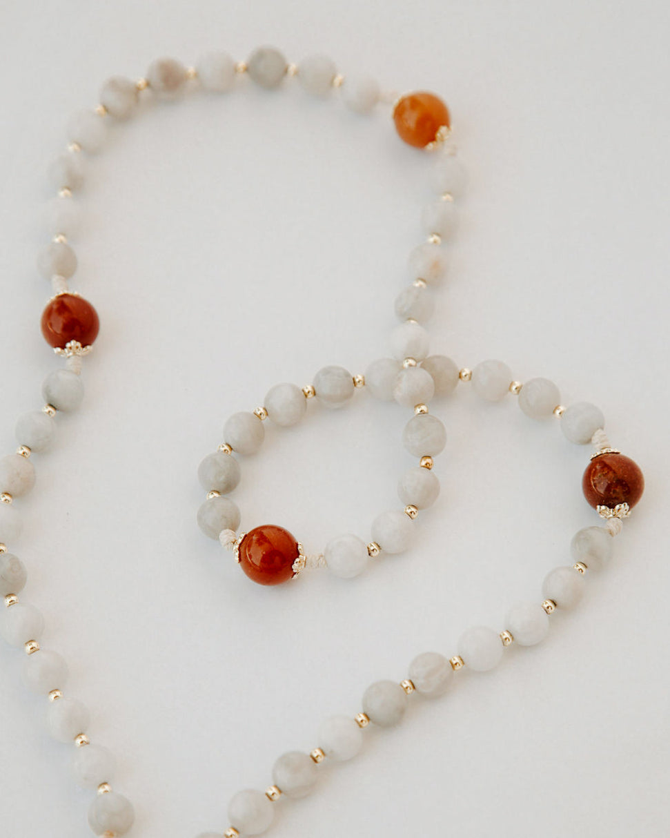 Rosary with white and orange beads on a white background