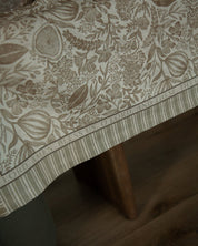 A Catholic tablecloth called the blessings tablecloth with a botanical design featuring the grace before meals prayer around the boarder. 