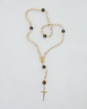 Rosary necklace with beads and a cross on a white background