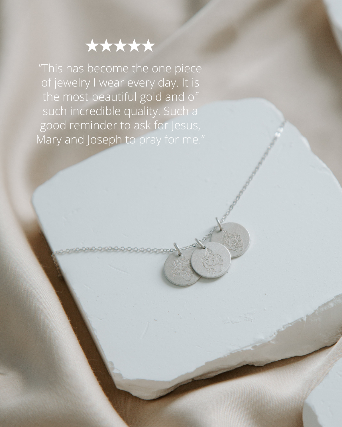 silver necklace on white stone with pink background