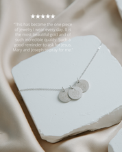 silver necklace on white stone with pink background