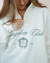 Person wearing a white sweatshirt with 'Kingdom Club' text and logo.