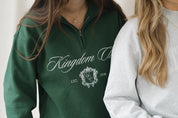 Person wearing a green sweatshirt with 'Kingdom' and 'W & C' branding.