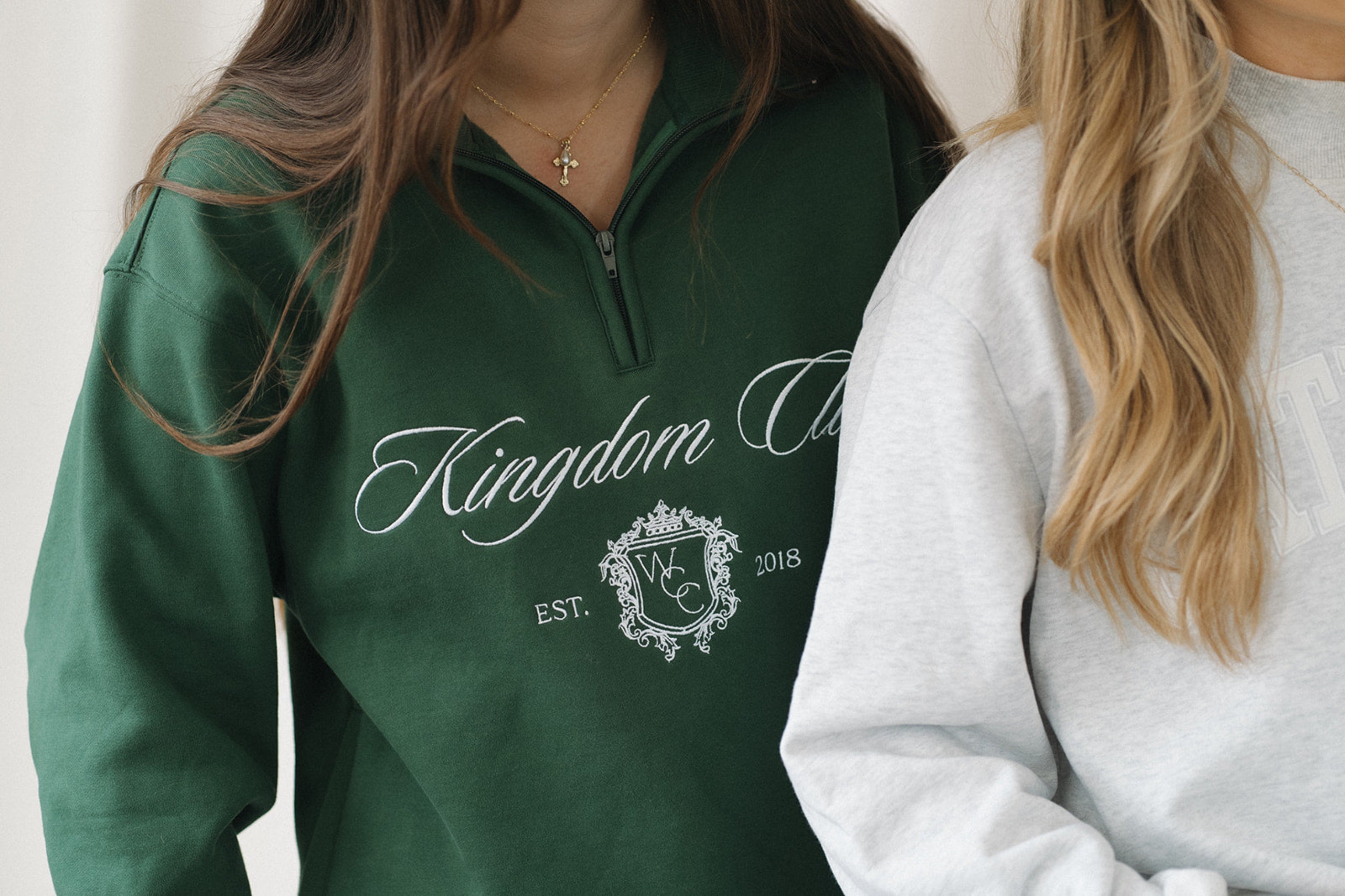 Person wearing a green sweatshirt with 'Kingdom' and 'W & C' branding.