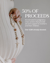 Rosary with beige and pink beads and a gold details on a light background