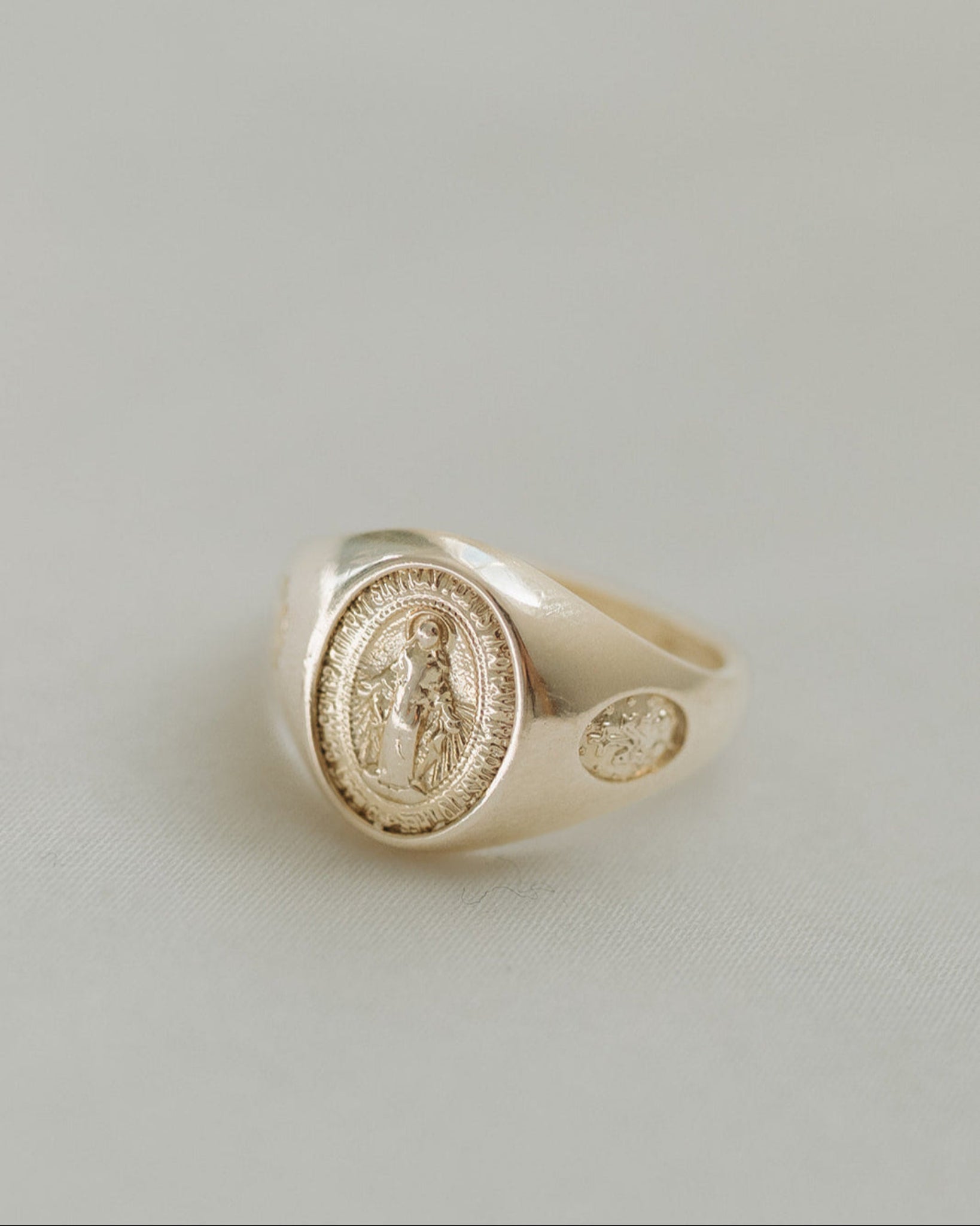 Gold Miraculous Medal Signet ring on a white background 