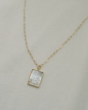 Gold pearl Guadalupe necklace on a light gray background