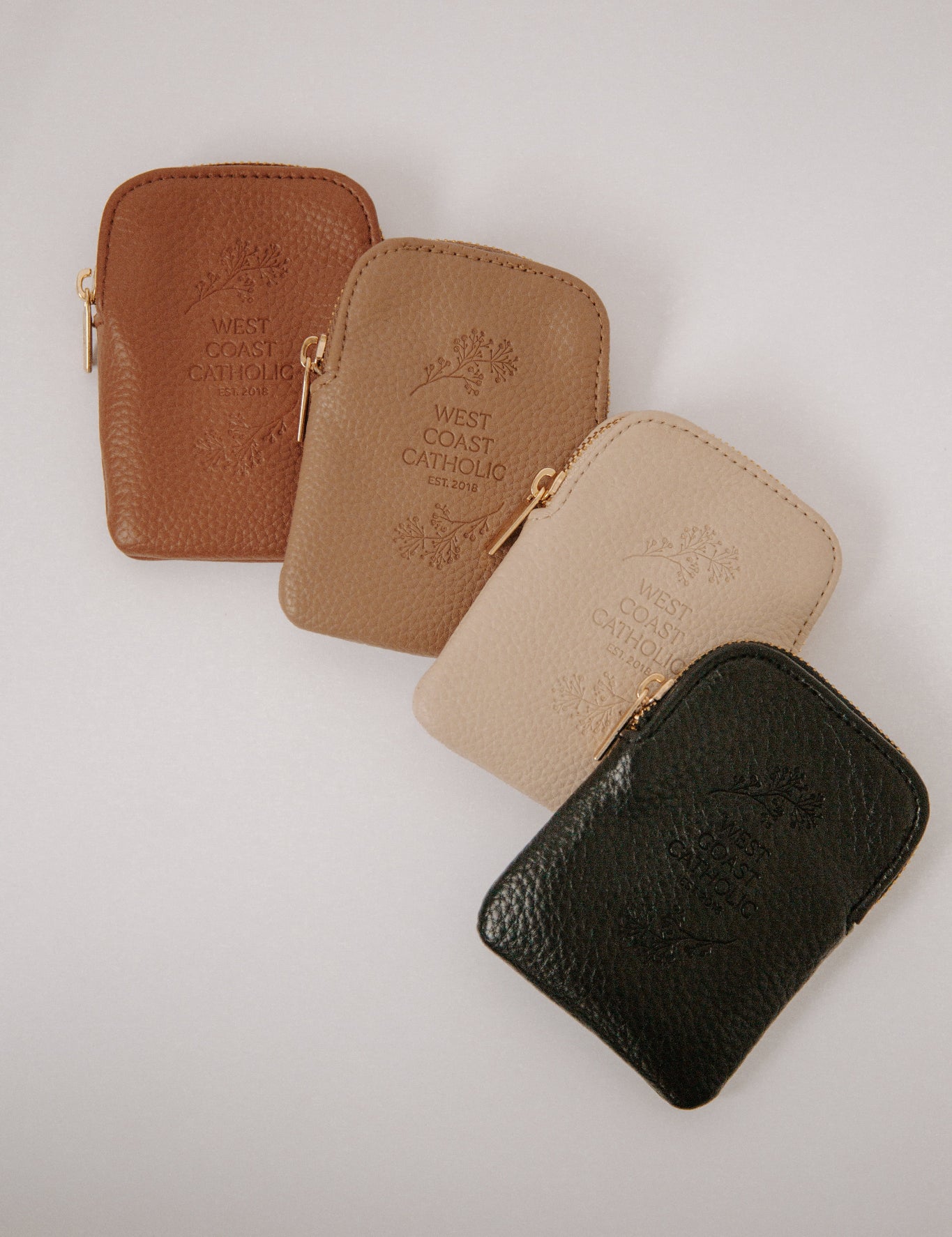 Four leather pouches in different colors on a light background