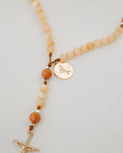 Rosary with cream and orange beads with gold medal on a white background