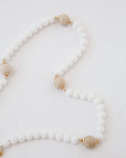 Rosary with white and beige beads on a light background