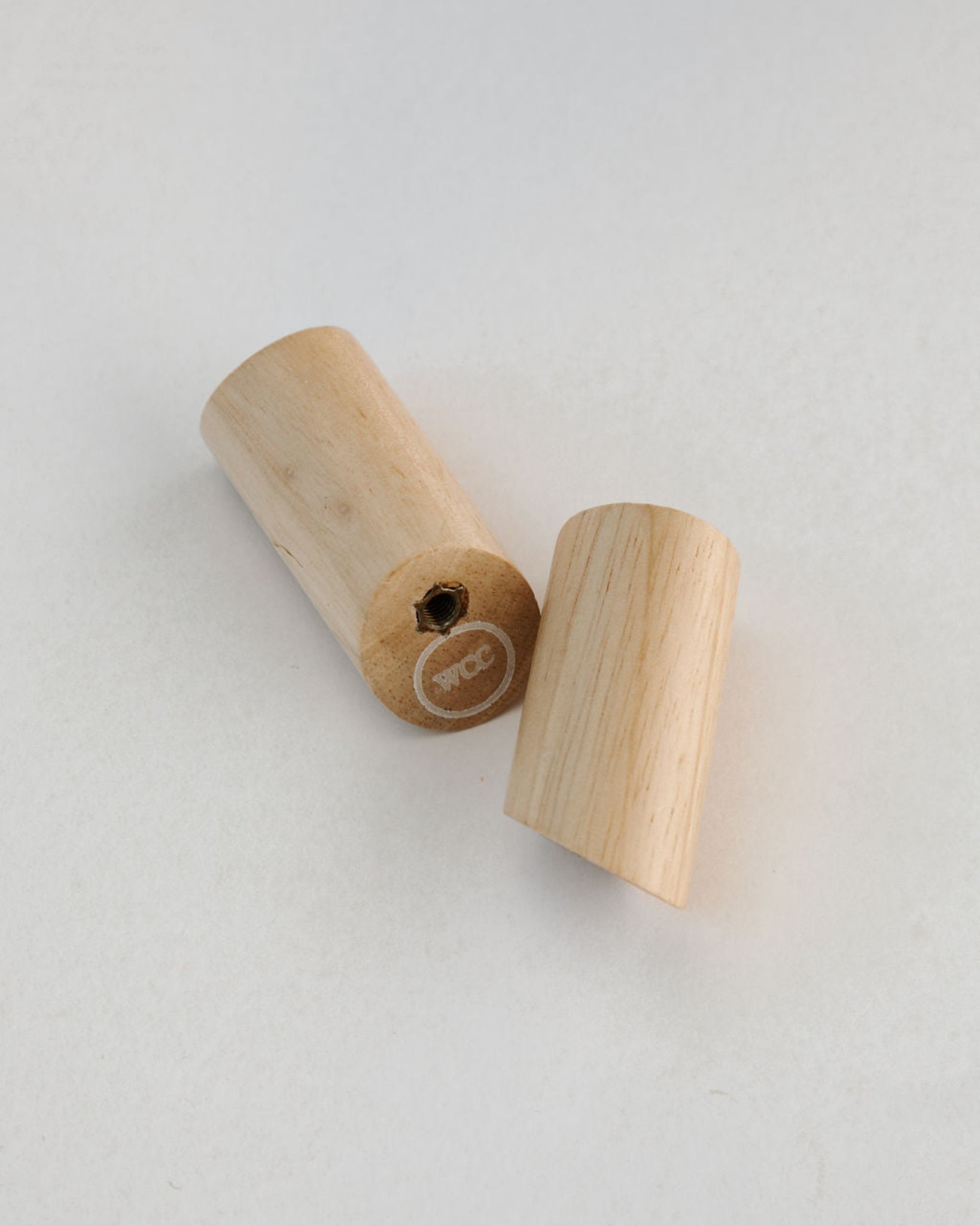 Two wooden rosary pegs on a light gray background