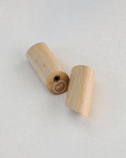 Two wooden rosary pegs on a light gray background