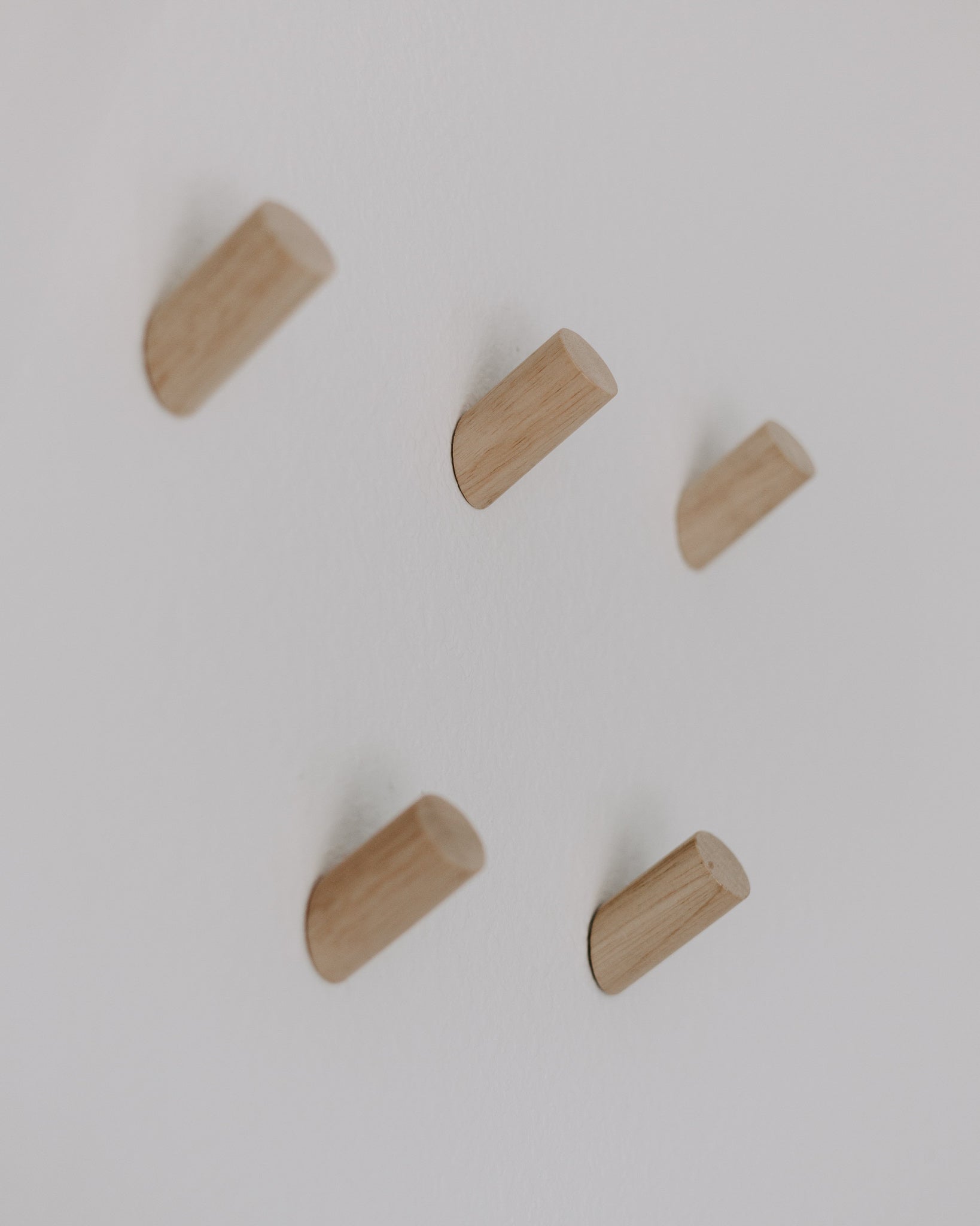 Five wooden rosary pegs on a white background