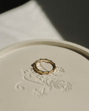 Gold rosary ring on a white surface with intricate designs