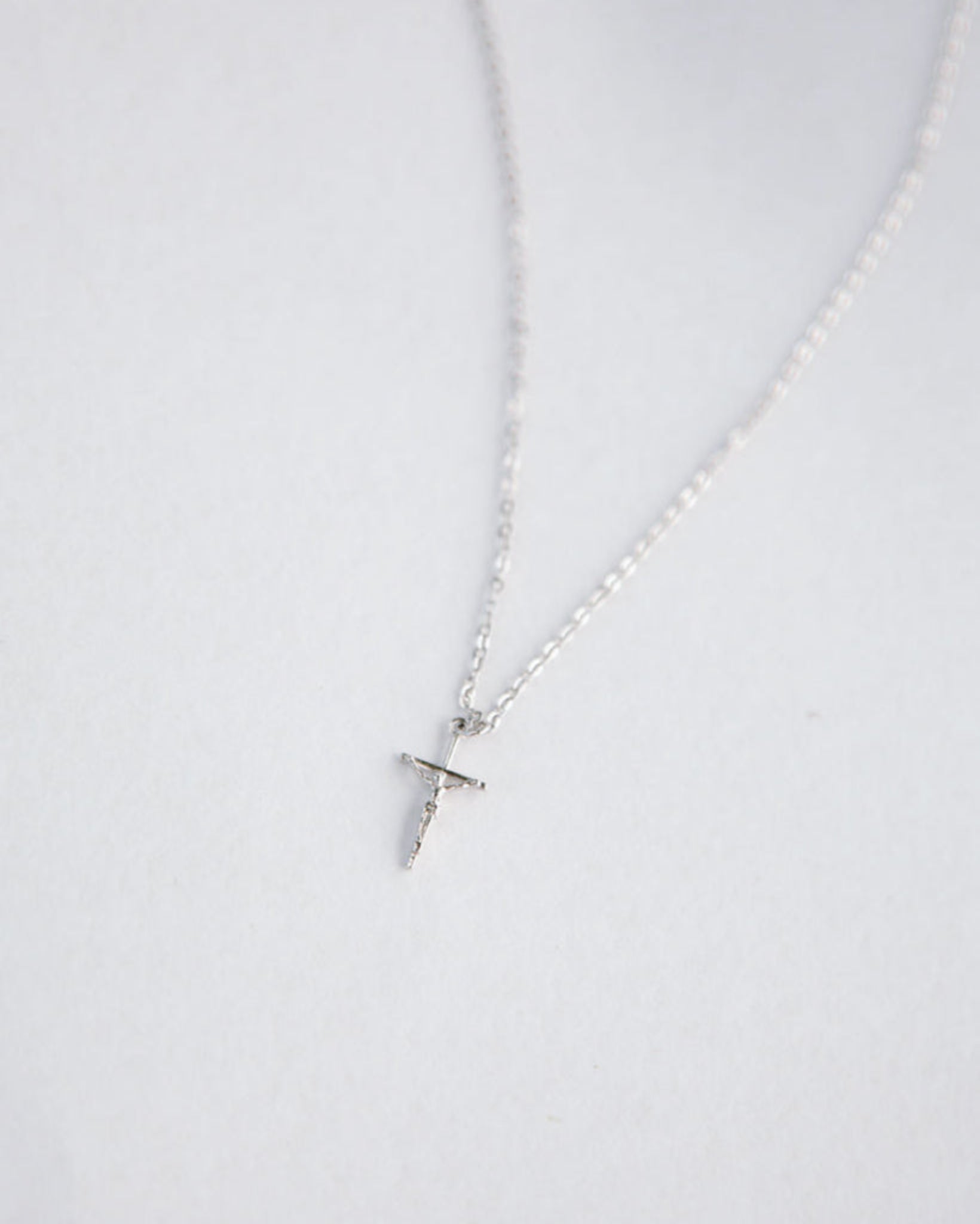 Silver necklace with a small pendant on a white background