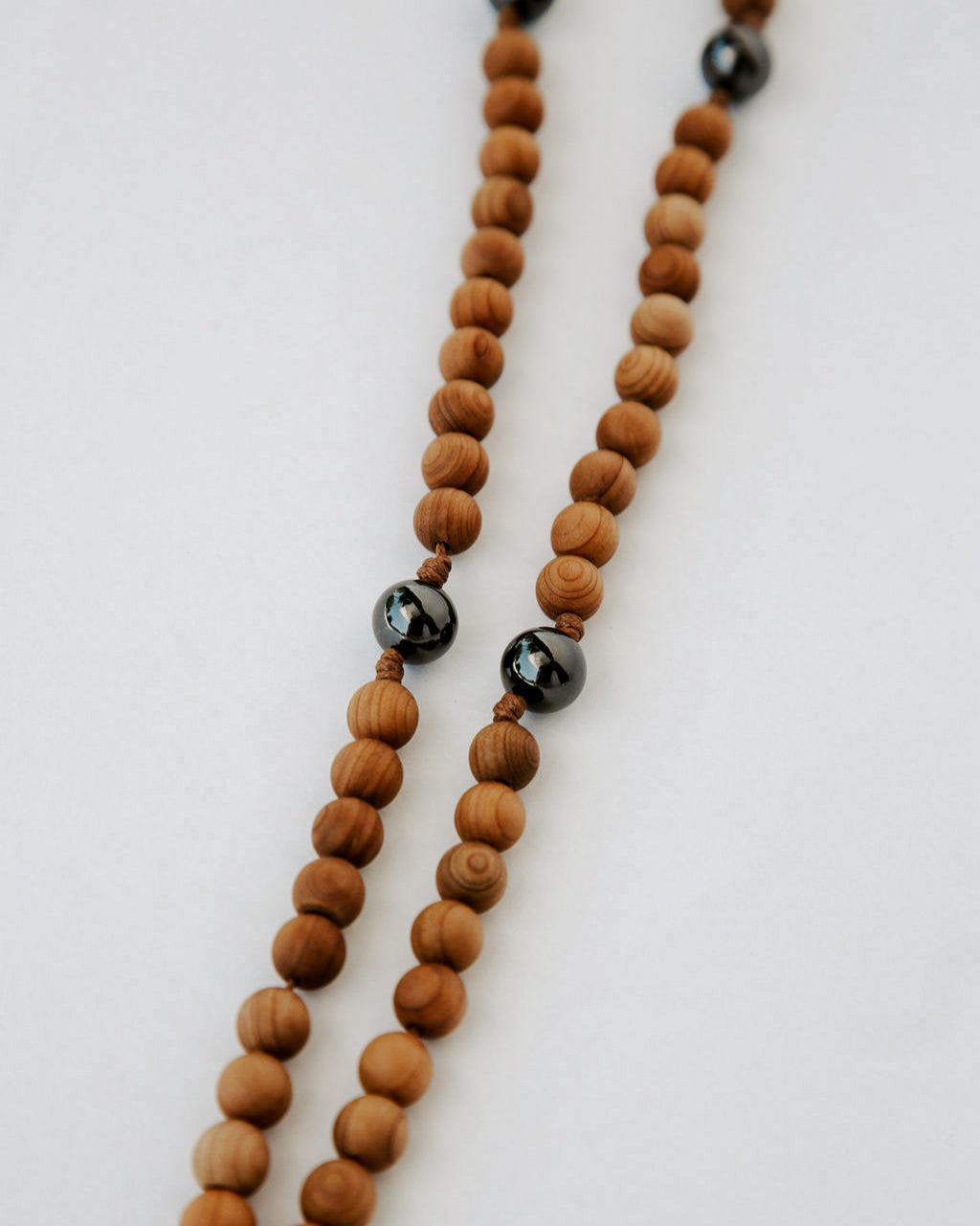 Wooden beaded rosary with black beads on a white background