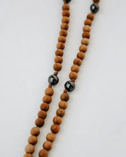 Wooden beaded rosary with black beads on a white background