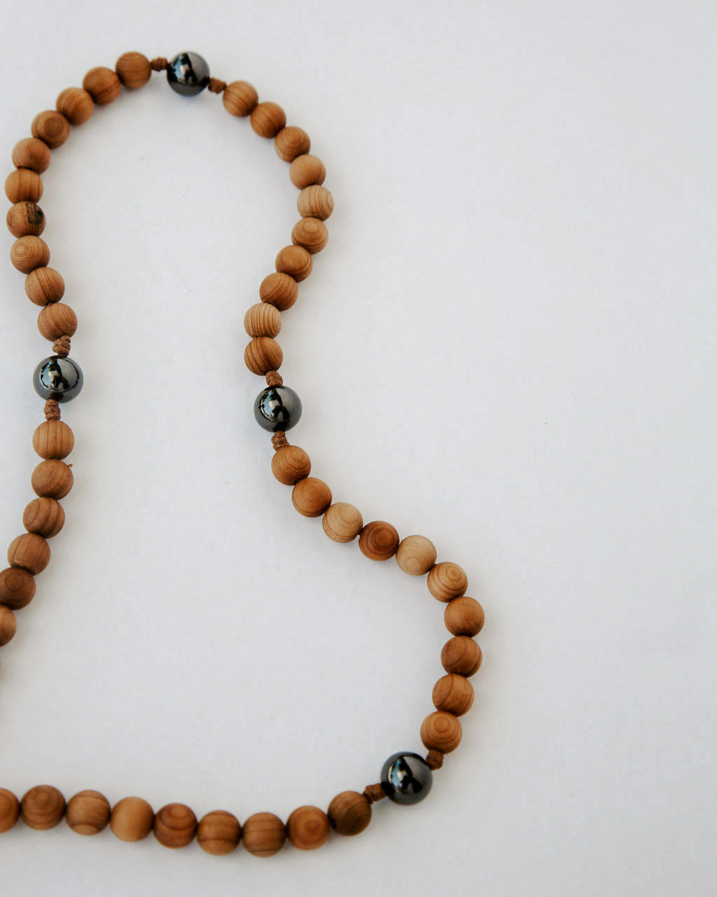 Rosary with wooden beads and black beads on a white background