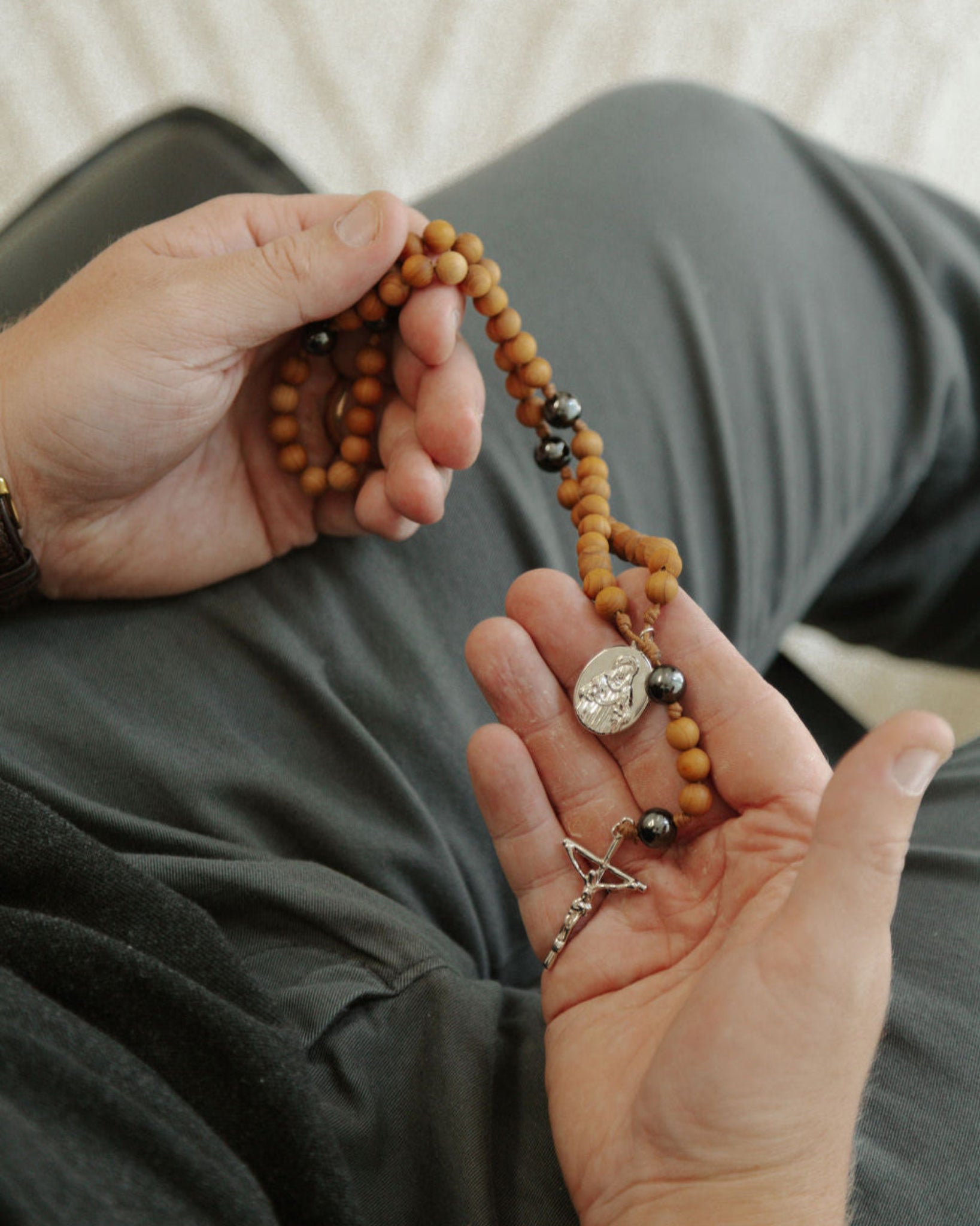 Person holding a rosary with a blurred background