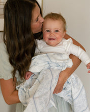 Baby with a Catholic West Coast Catholic swaddle.