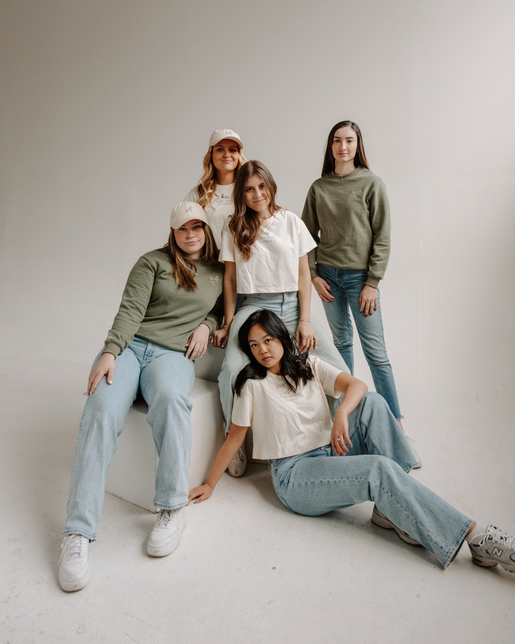 Five women posing together in a studio setting wearing wcc apparel