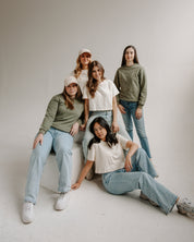 Five women posing together in a studio setting wearing wcc apparel