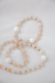 Pink and white immaculate heart rosary beads on white background