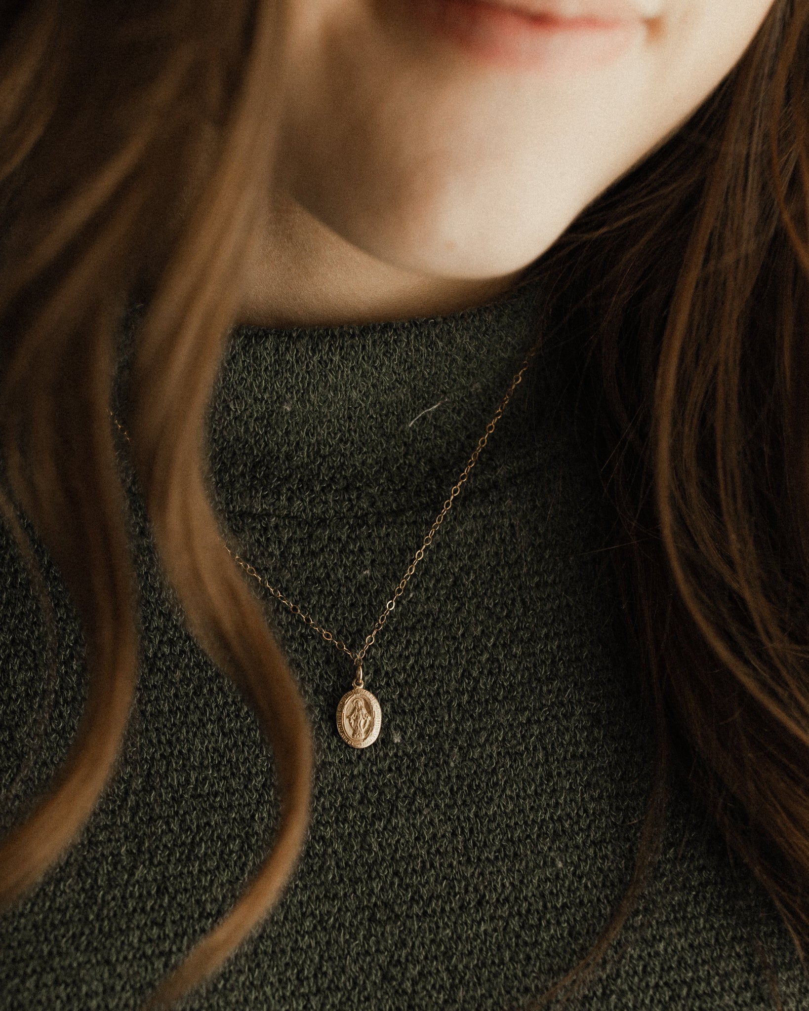 Woman wearing a gold miraculous medal