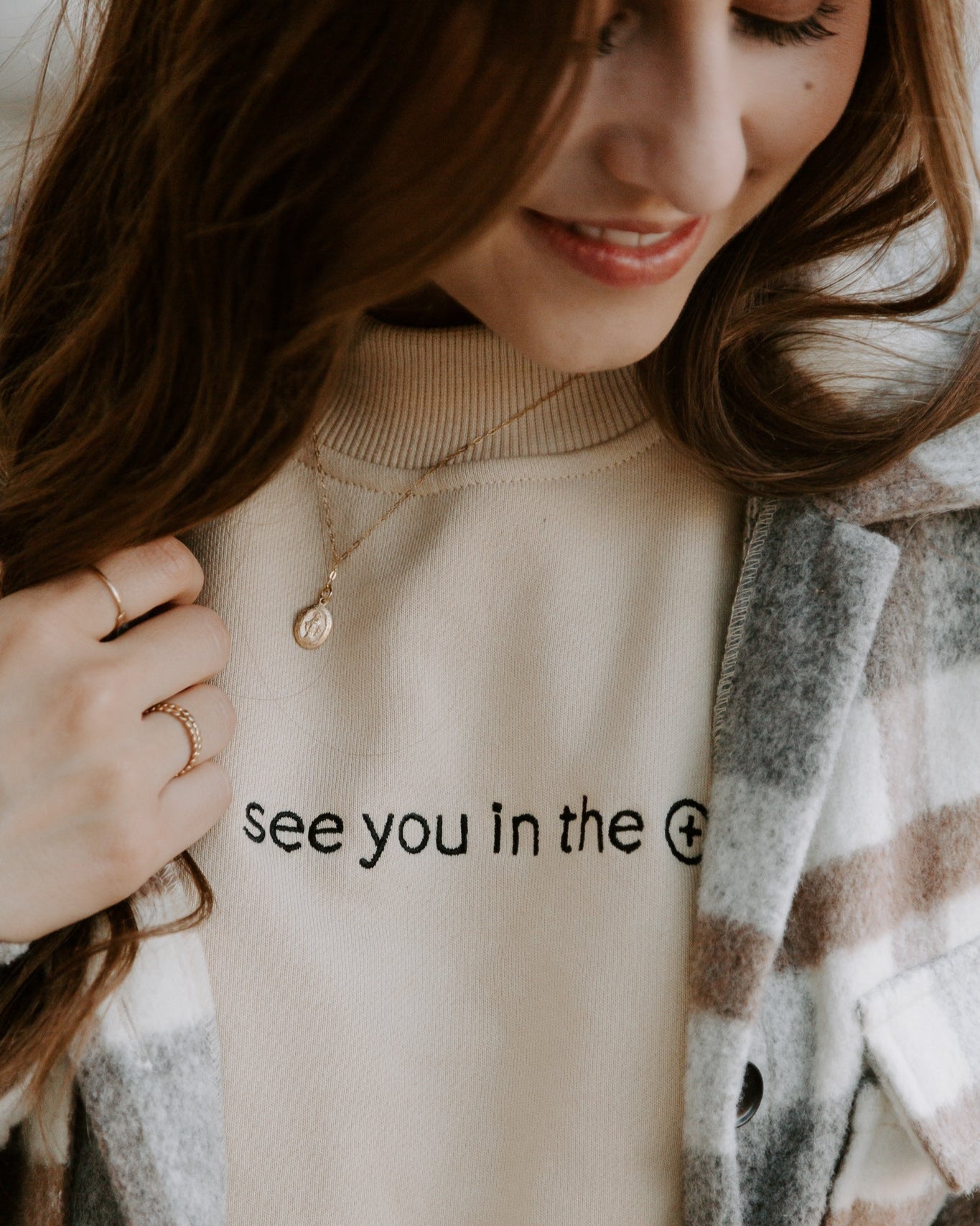 Woman wearing see you in the eucharist sweater