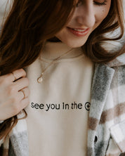 Woman wearing see you in the eucharist sweater