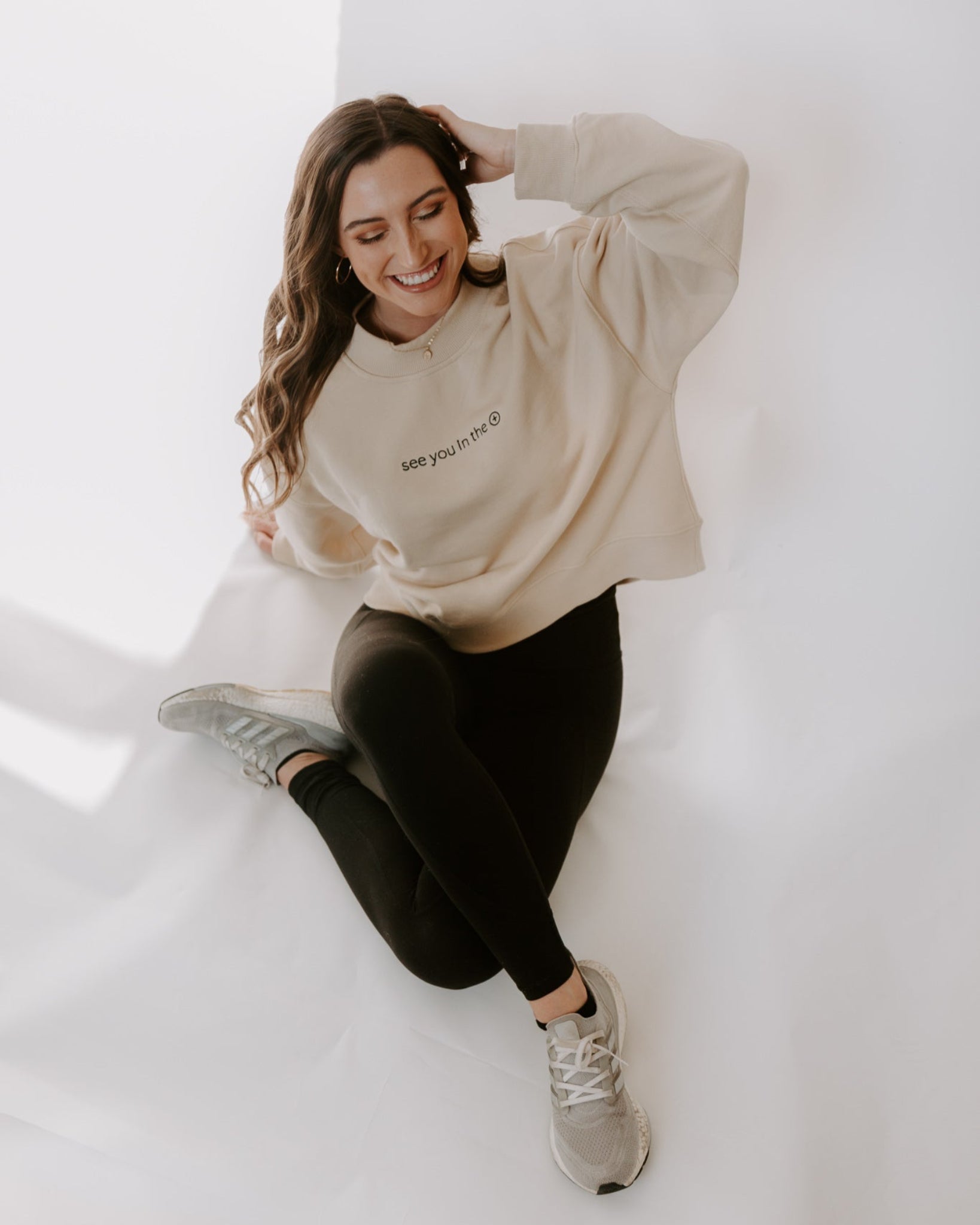 Woman wearing a beige sweater on white background