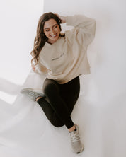 Woman wearing a beige sweater on white background