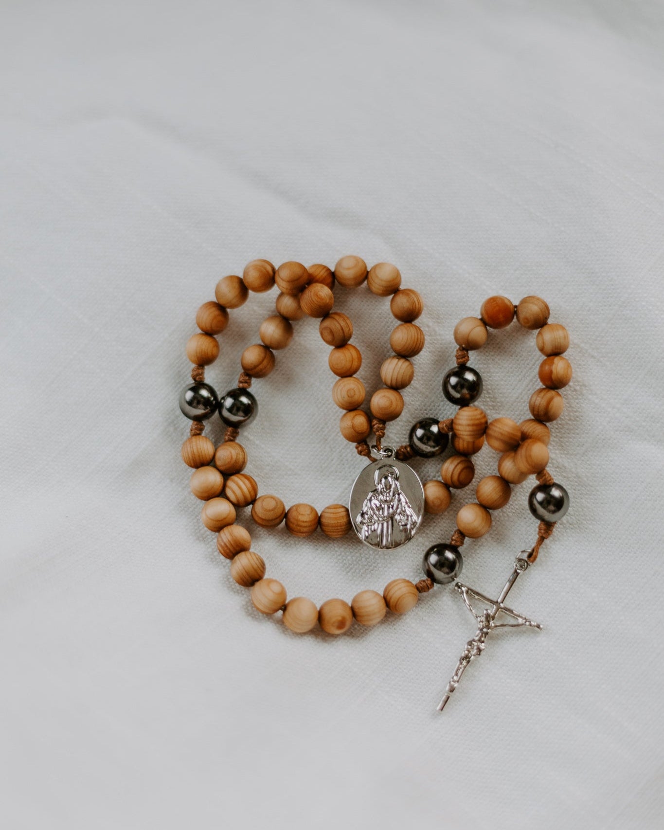Wooden rosary with black beads on a light background